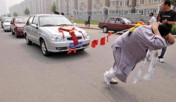 52-летняя китаянка протащила 6 автомобилей, привязав их к своей косе. ФОТО